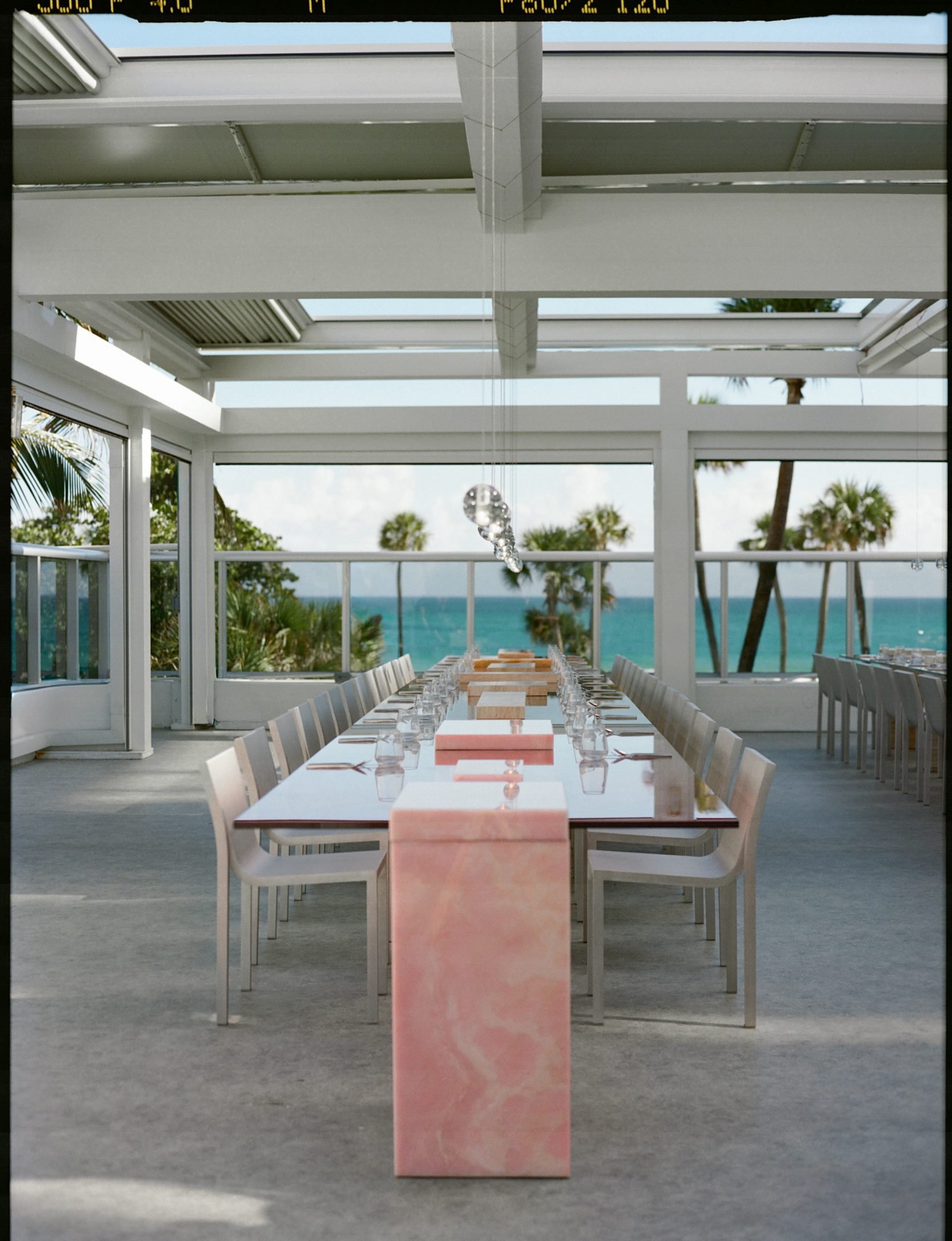 Pink onyx tabletop and banquette setting in the daylit Sabine Marcelis environment at Andaz Miami Beach for We Are Ona, photographed by Alicia Valdez